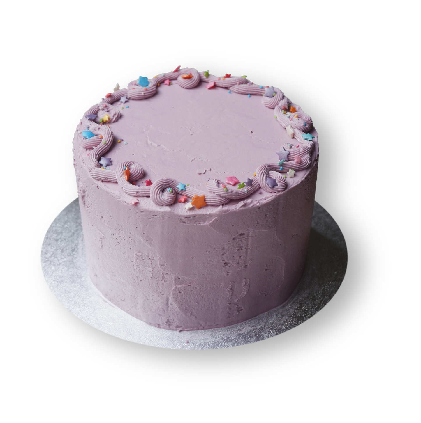 Fun lilac cake with simple piping at the top with rainbow stairs sprinkles.