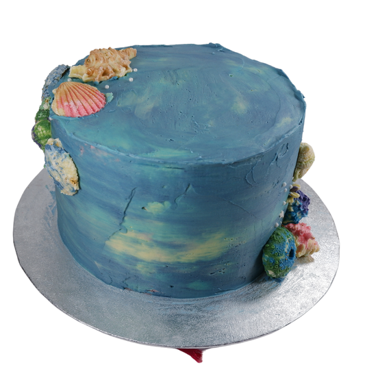 Different shade of blue cake with colourful chocolate shells.