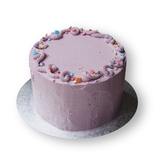 Fun lilac cake with simple piping at the top with rainbow stairs sprinkles.